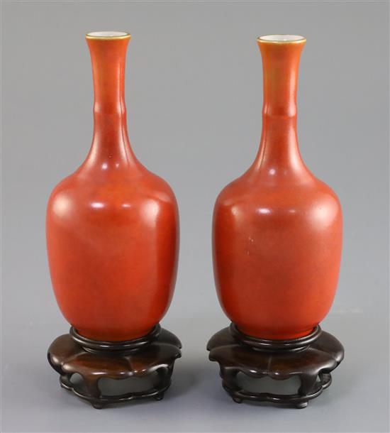 A pair of Chinese coral ground bottle vases, Hongxian mark, Republic period, H. 14cm, wood stands, hairline crack to one vase